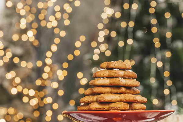 Christmas tree made of gingerbread snowflakes on the background of blurry glow of garlands