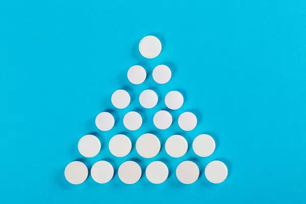 Christmas tree made of pills on a blue background