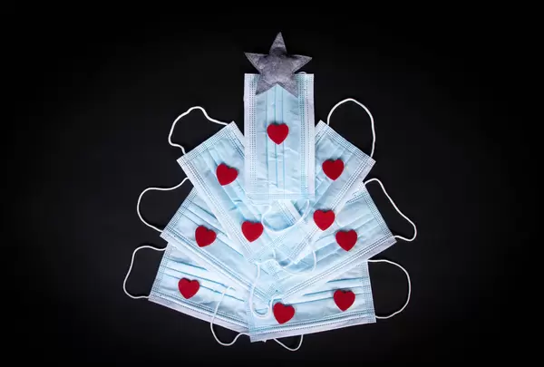 Christmas tree made out of medical face masks on black background