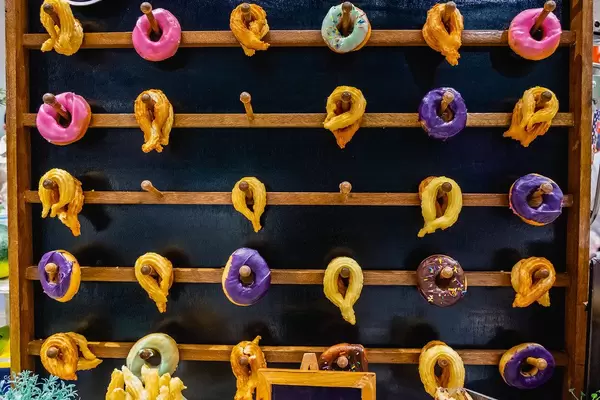 Churros and doughnuts hanging on wooden shelf