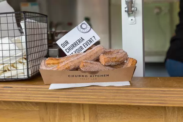 Churros on a paper plate: Iberian crispy pastry with sprinkled sugar