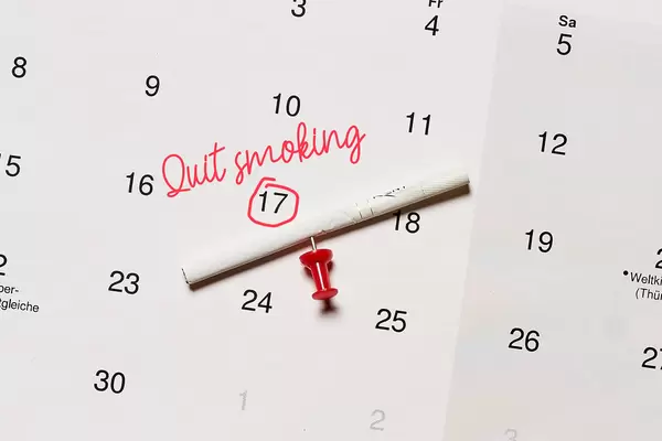 Cigarette and calendar with the marked date of quit smoking