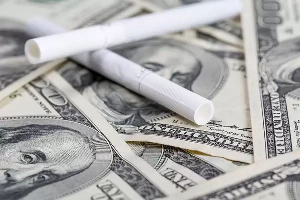 Cigarettes laying on us dollars, close up