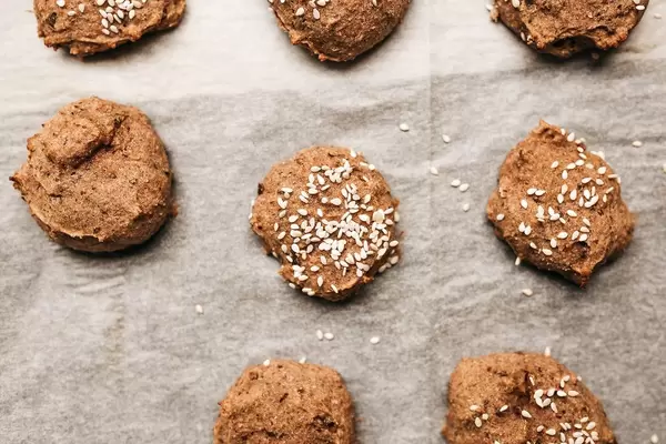 Cinnamon sesame seed sprinkled cookies on baking sheet