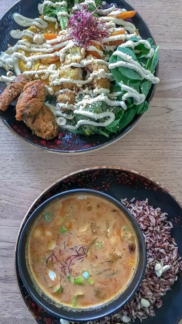 Clean Eating in healthy Restaurant Edelgrün in Cologne, Germany, with photogenic food: Green veggie bowl and soup on black plates