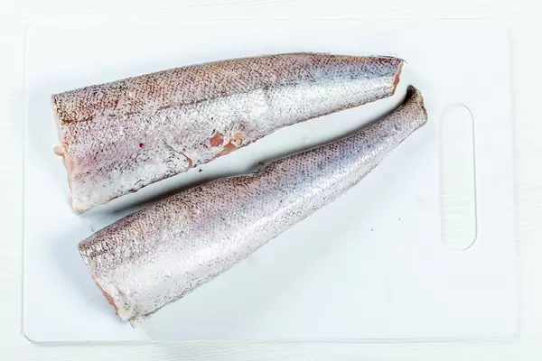 Cleaned raw fish on a white kitchen Board