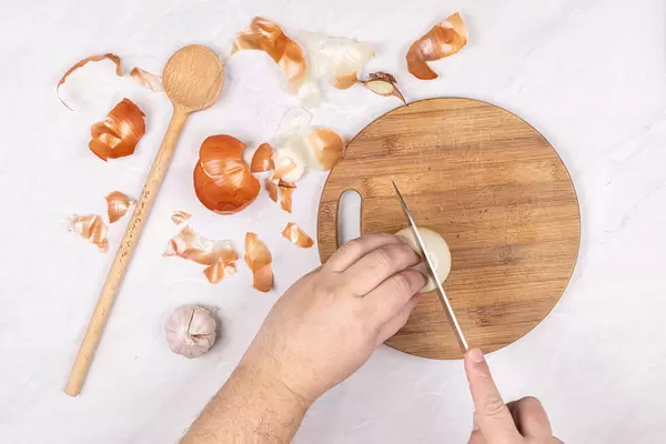 Cleaning and cutting Onions with knife in the hand