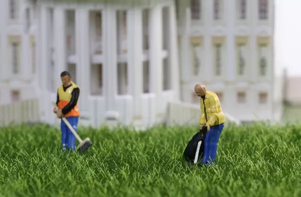 Cleaning workers standing on the grass in front of building