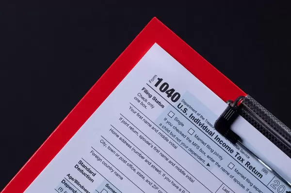 Clipboard and 1040 form isolated on black