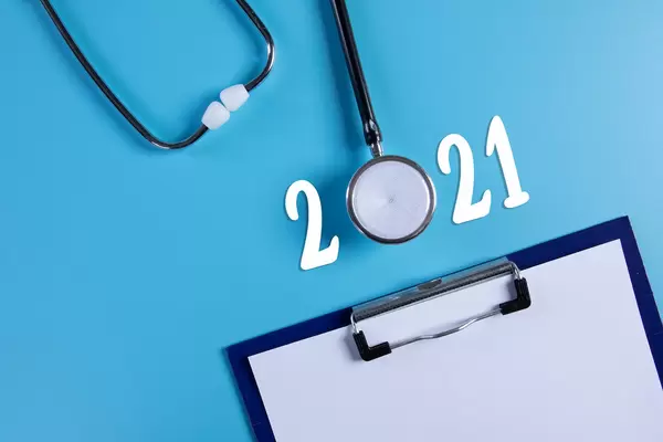 Clipboard and stethoscope with 2021 text on blue background
