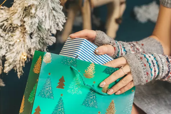 Close-up, a girl takes out a box from a gift bag