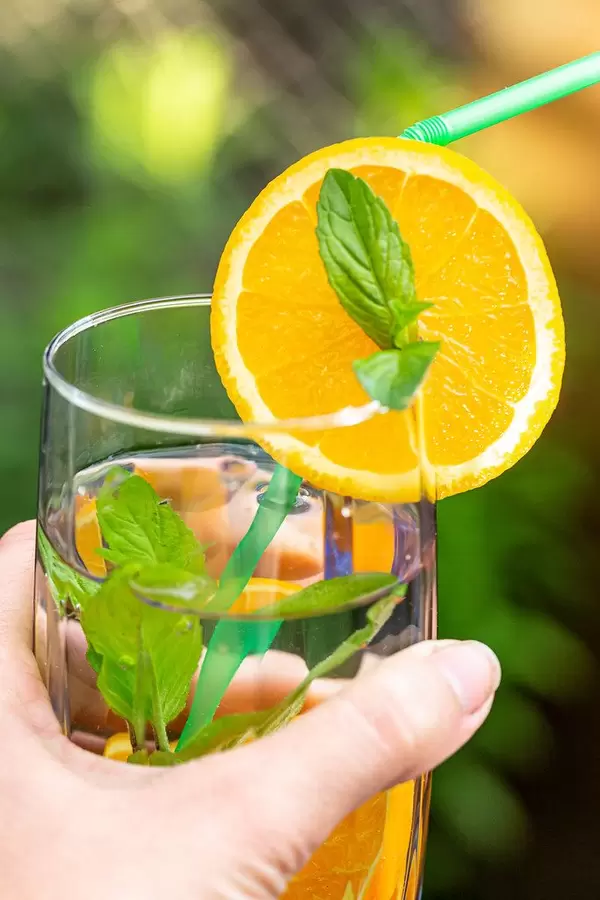 Close-up, a glass with a summer drink in a woman's hand