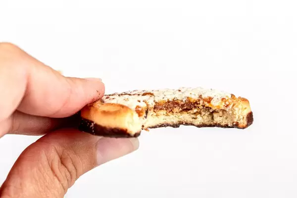 Close-up, a piece of cookie in a woman's hand
