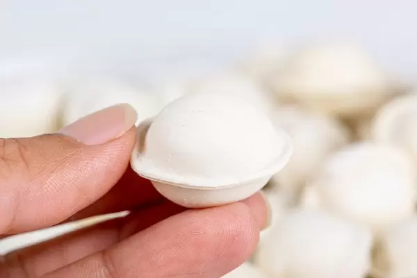 Close-up, a small raw dumpling in a woman's hand