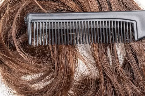 Close- up, black comb on dark female hair