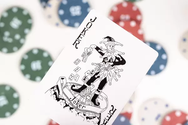 Close-up, black Joker on a blurry background of playing chips