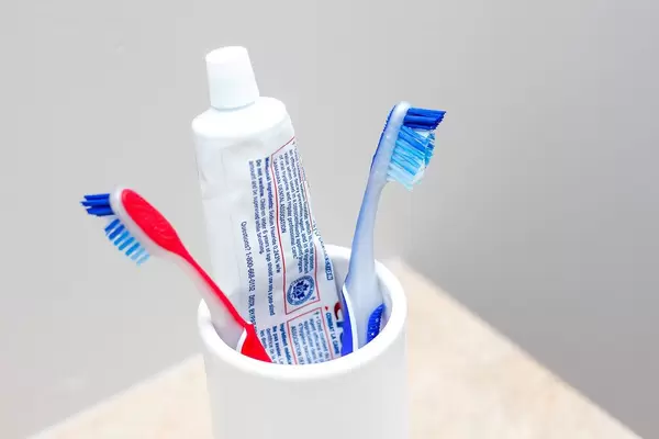 Close Up Bokeh of Toothbrushes and Toothpaste in a cup