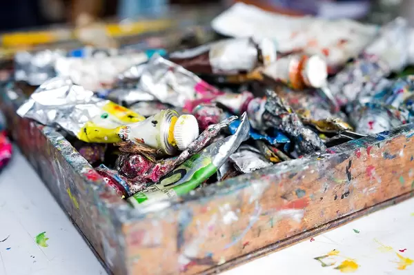 Close Up Bokeh Photo of used colorful Acrylic Paint Tubes in Artist Box