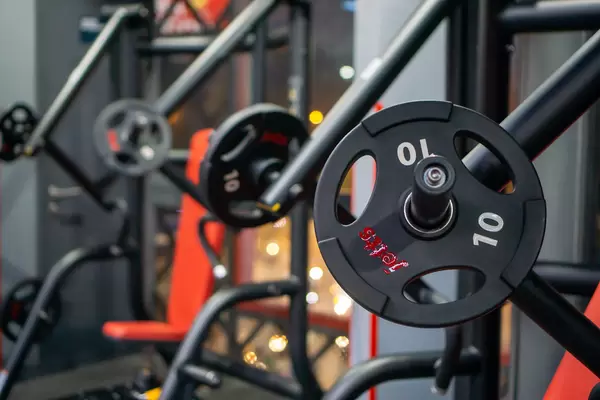Close Up Bokeh Photo of Weight Plate on an Incline Chest Machine with Seated Neutral Chest Press Machine in the Background