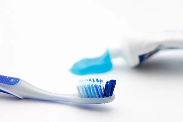 Close Up Bokeh Shot of Toothbrush with Toothpaste in Background
