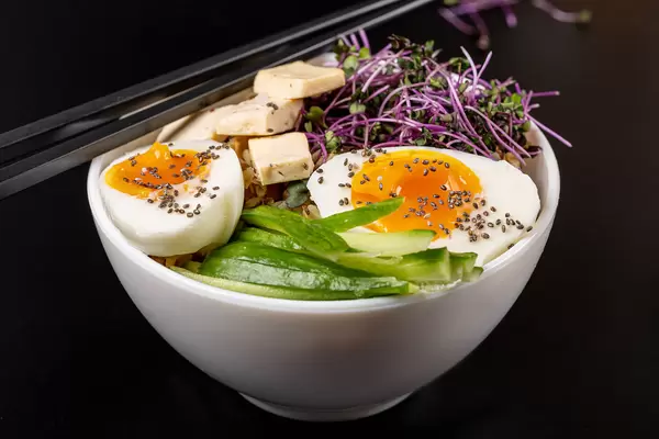 Close-up, bowl of porridge with cucumber, cheese, microgreens and chicken egg