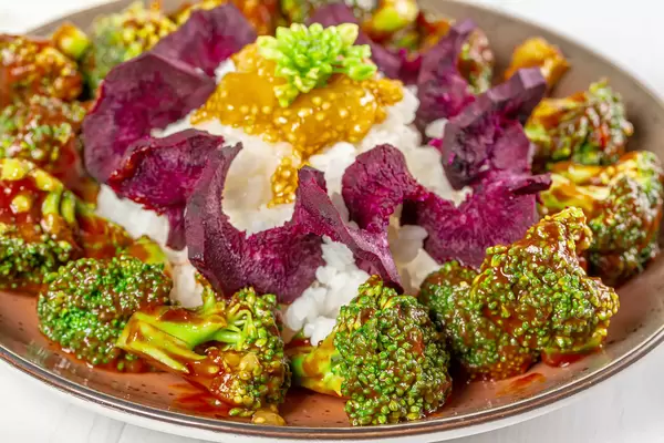 Close-up, broccoli in tomato sauce with rice, purple carrots and guava