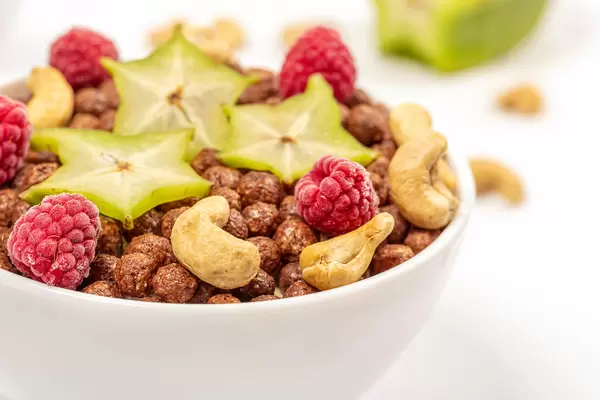 Close-up, chocolate corn balls with cashew nuts, raspberries and carom pieces