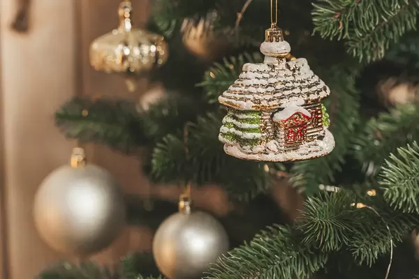 Close-up decoration of a small house hanging on a christmas tree