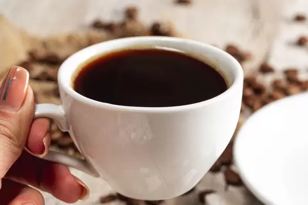 Close-up einer Tasse Kaffee in der Hand einer Dame