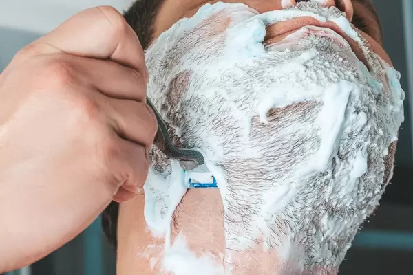 Close-up eines Mannes der seinen Bart rasiert