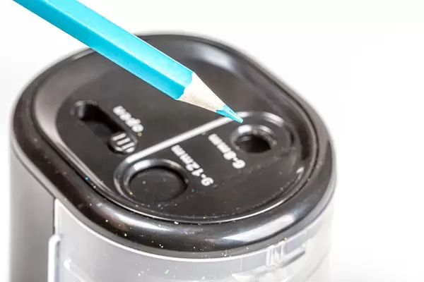 Close-up electric black sharpener with blue pencil