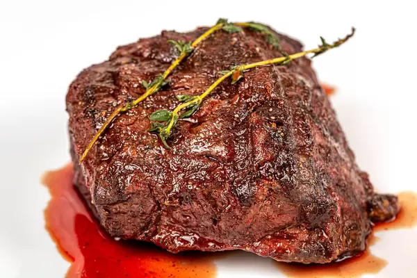 Close-up filet mignon with sauce and a sprig of thyme