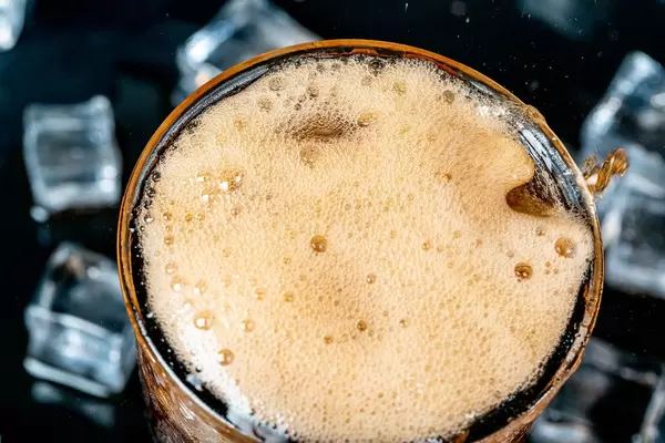 Close-up, foam and bubbles in a glass with cold pepsi