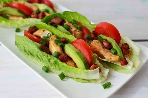 Close Up Food Photo of BLAT Wraps with Buffalo Chicken on a White Plate