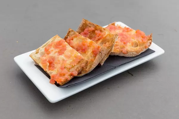 Close Up Food Photo of Catalan Bread Pan de Cristal con Tomate Spanish Tapas on white Plate