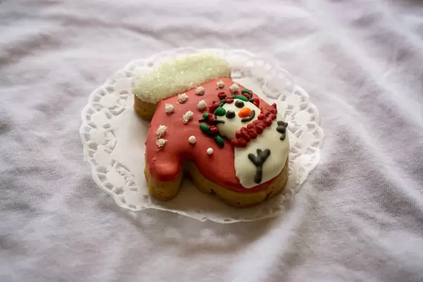 Close Up Food Photo of Christmas Gingerbread Cookie in Gloves Design with Snow as Sugar and Snowman Icing Decoration on Top