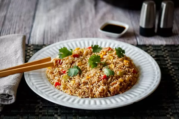 Close Up Food Photo of Fried Rice on White Plate with Chopsticks and Soy Sauce