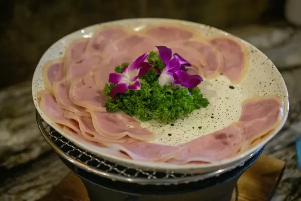 Close Up Food Photo of Ham Cold Cut with Parsley and Flower Decorations on a Plate at a Complimentary Breakfast Buffet at a Hotel