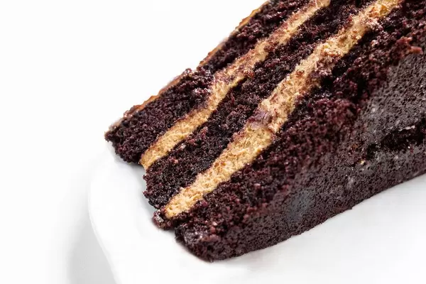 Close Up Food Photo of Homemade Chocolate Cream Cake Dessert on white Plate