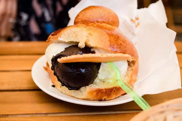 Close Up Food Photo of Ice Cream Sandwich Sicilian Brioche Bun stuffed with Ice Cream on Wooden Table