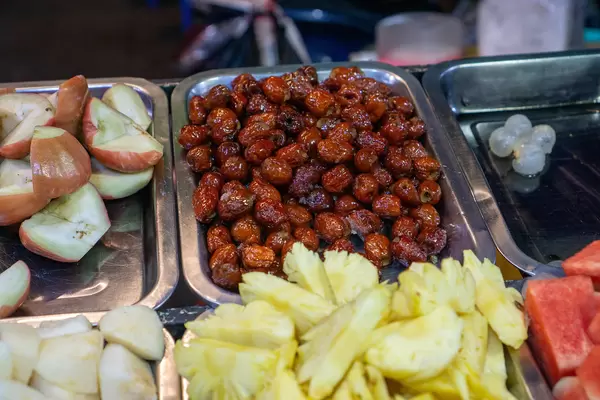 Close Up Food Photo of Plum, Lychee, Apple, Pineapple, Watermelon, Glazed Dates and other Fruits on a Dessert Fruit Bowl Place at a Night Market in Can Tho, Vietnam