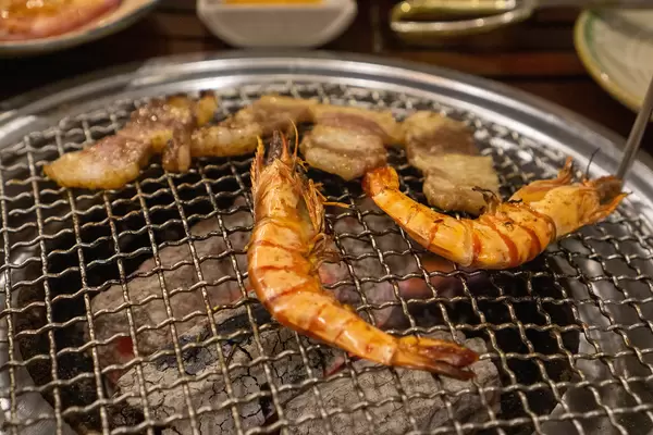 Close Up Food Photo of Shirmps and Pork Bacon on a Charcoal Barbecue Grill at a Buffet Restaurant in Vietnam