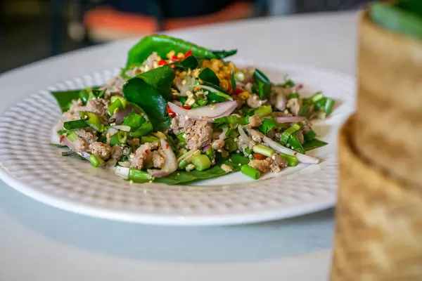 Close Up Food Photo of Thai Basil Beef Pad Gra Prow with Lemongrass, Basil, Onions, Chili and Lemon Leaves on a Plate in a Restaurant