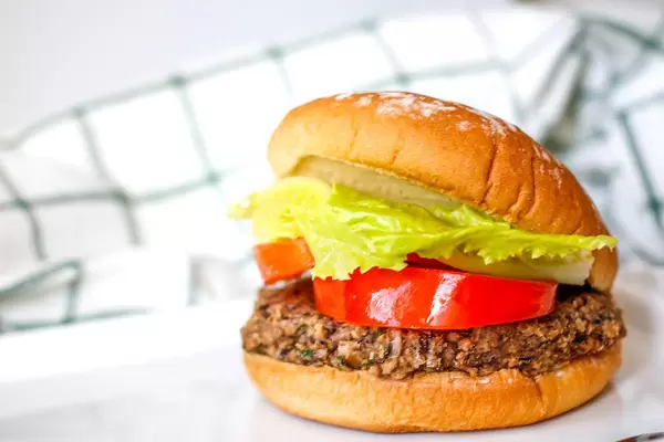 Close Up Food Photo of Vegan Burger with Black Bean Patty, Tomatoes and Lettuce