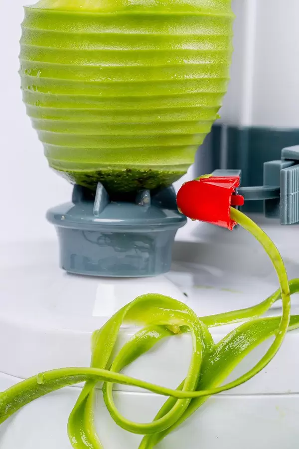 Close-up, green avocado in a peel machine