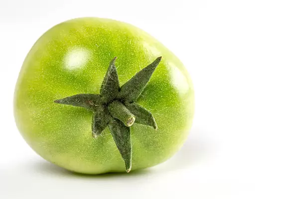 Close-up, green tomato on white background