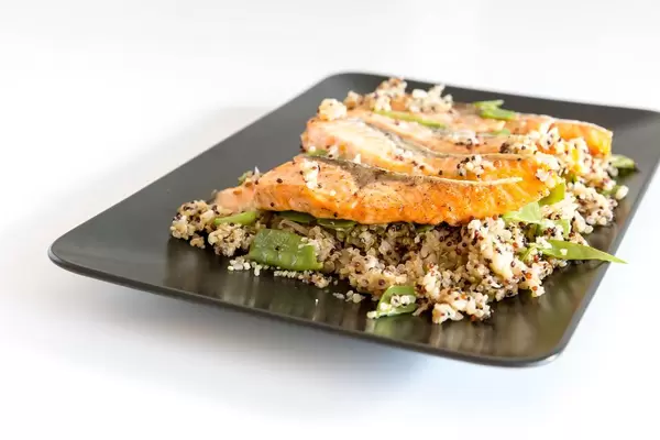 Close-up grilled salmon steaks with cauliflower quinova and parmesan chips