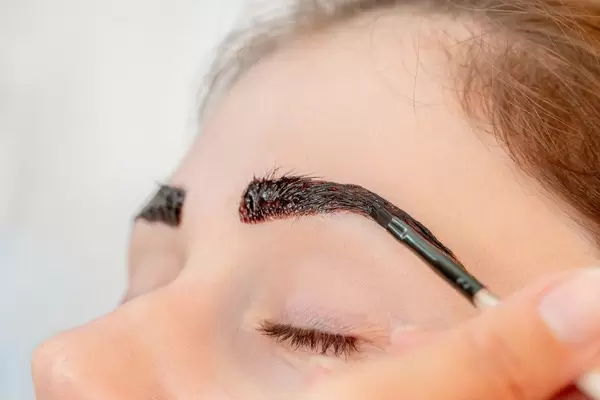 Close-up, henna staining a woman's eyebrows