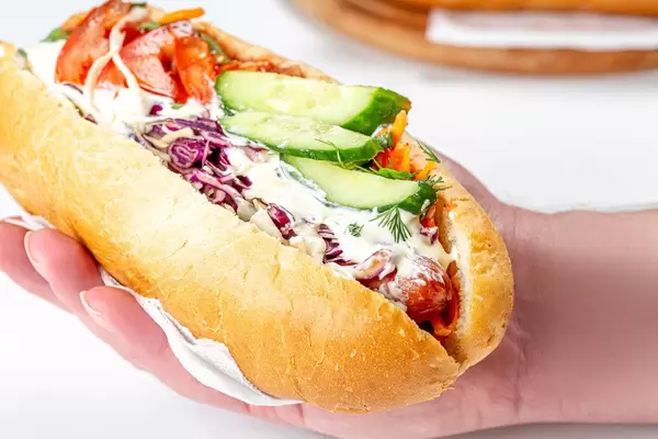 Close-up, hot dog with sausages and vegetables in hand (Flip 2020)