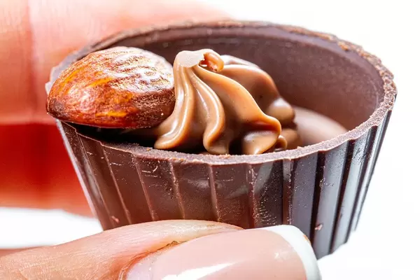 Close-up in a woman's hand chocolate candy with almonds (Flip 2019)